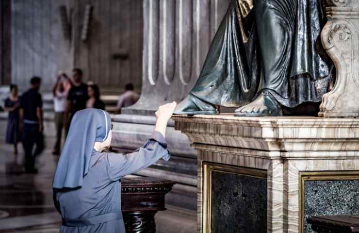 Suora che prega in chiesa